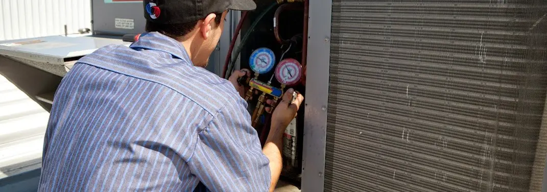 HVAC technician servicing a condenser unit in Wilmington Island